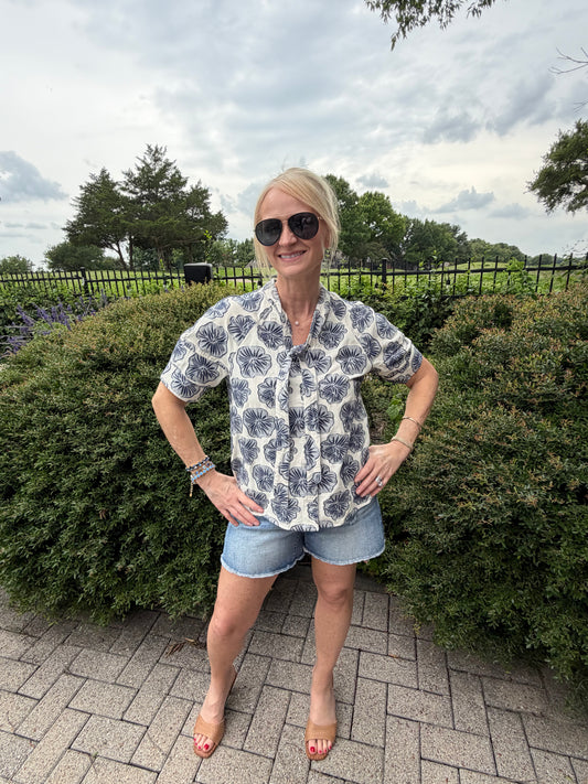 linen and cotton short sleeve blouse with button down and tie collar with light denim and dark denim blue flower design with denim shorts