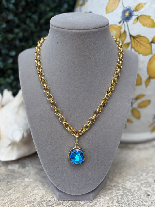 round royal blue crystal charm set in gold bezel on a gold necklace