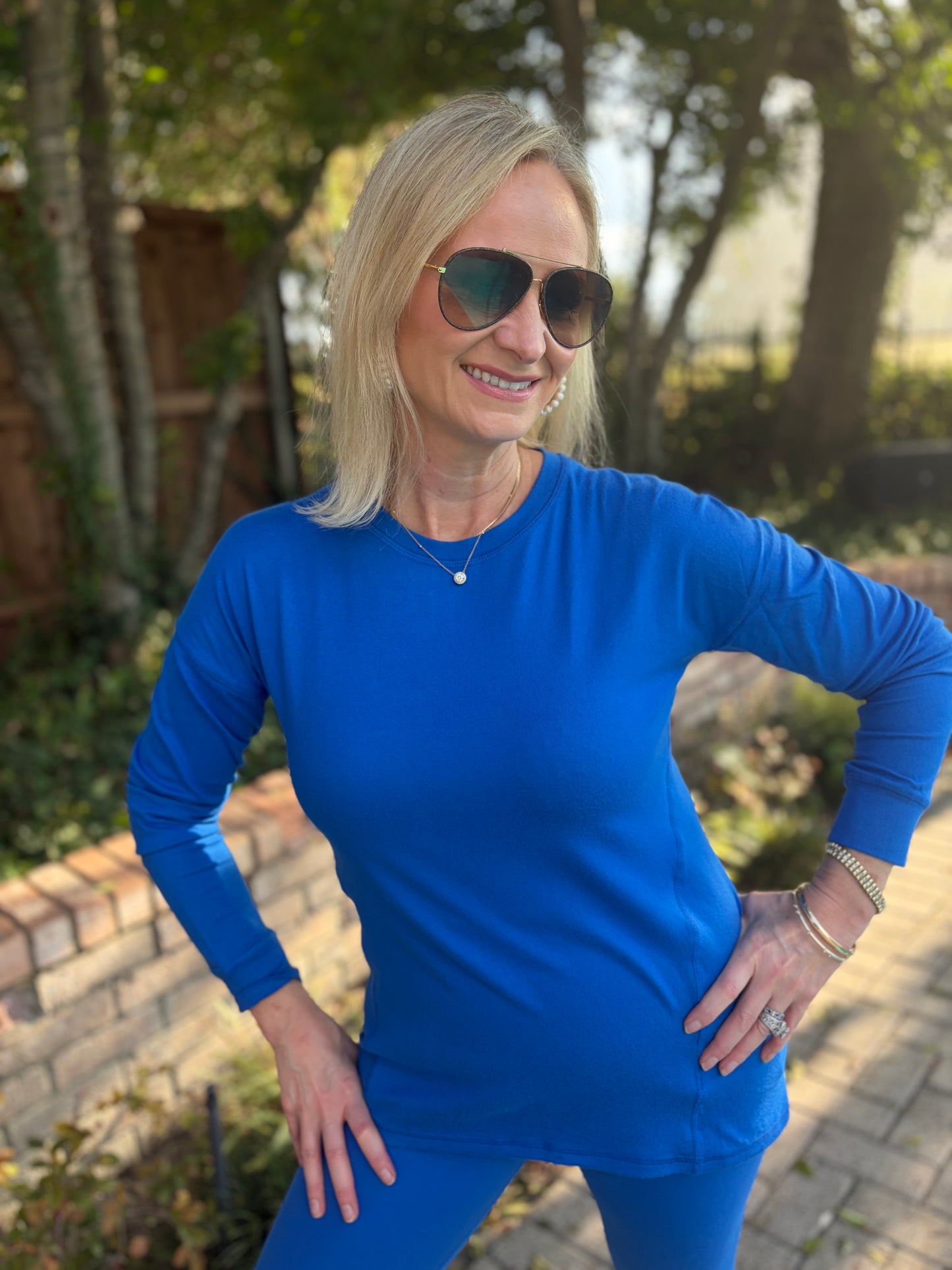  a royal, indigo crew neck tee that is long sleeved with seam from side coming down a bit on front. 