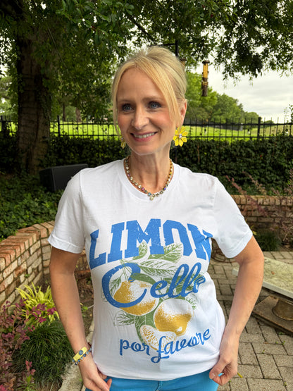 Woman wearing a white short sleeve tee that says Limon Cello. Design of lemons with blue writing. 