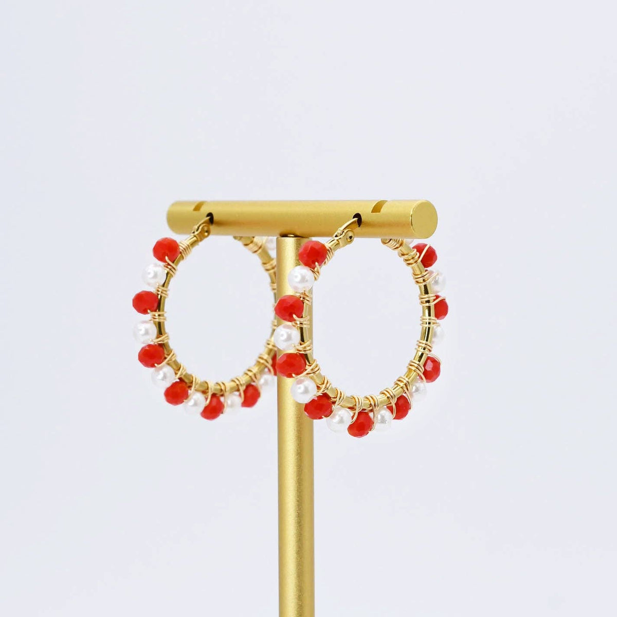 Gold hoop earrings with dangling red and white beads