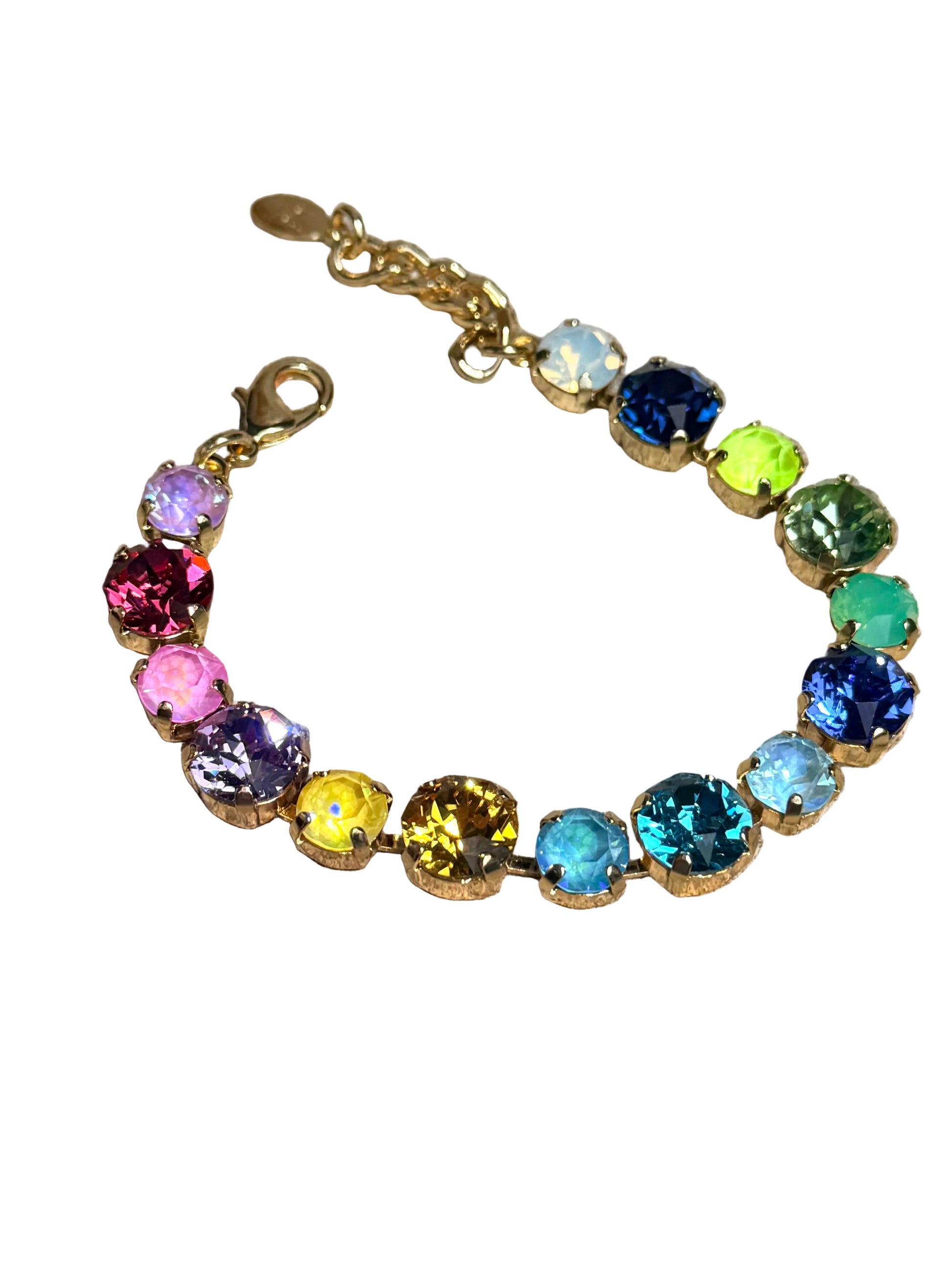 A gold-tone chain bracelet adorned with multiple round, faceted gemstones in a rainbow of colors, displayed on a textured gray concrete surface.