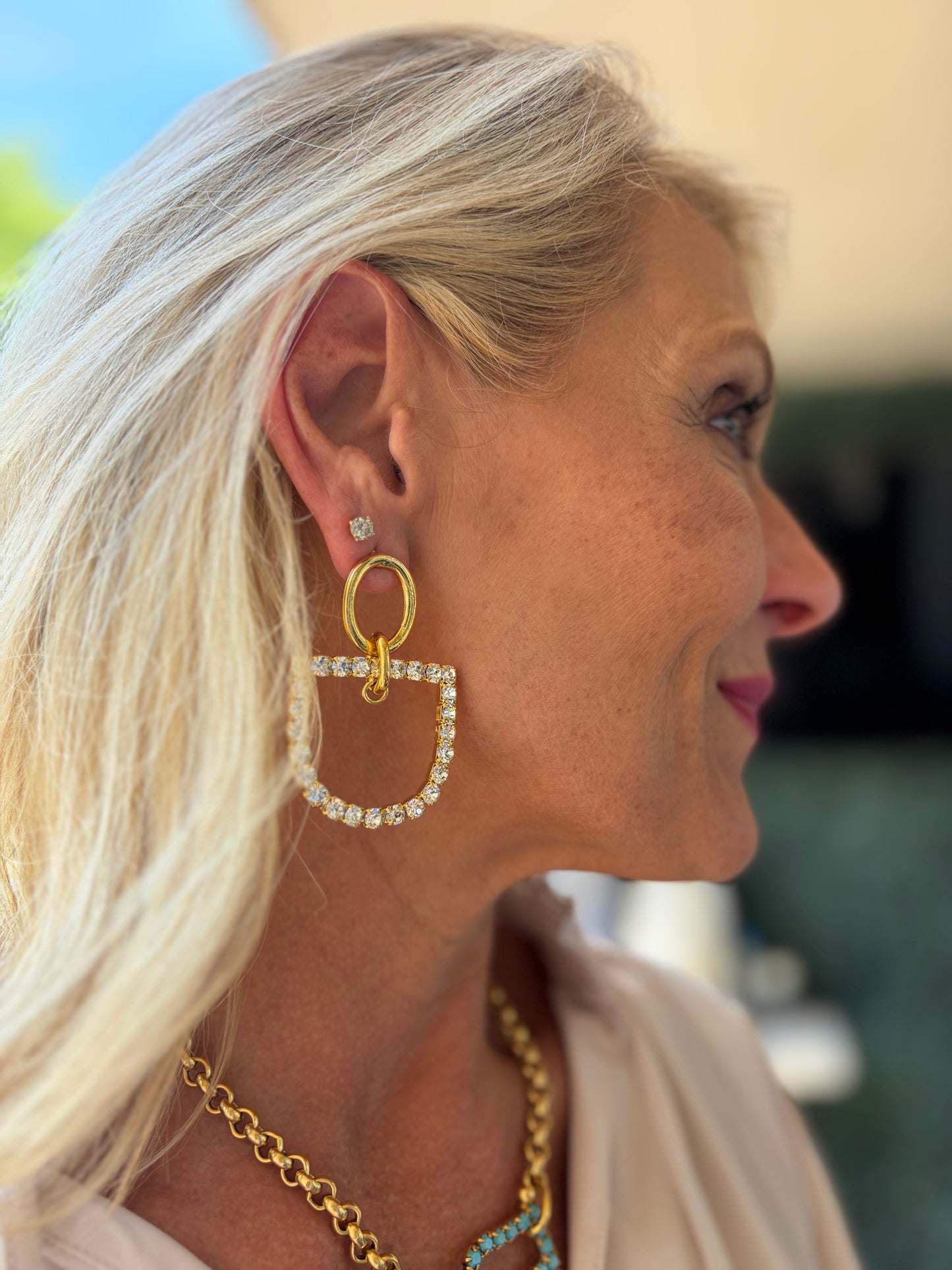 a stunning horsebit shaped earring in 22k gold plating dangle with bit adorned with rhinestones.