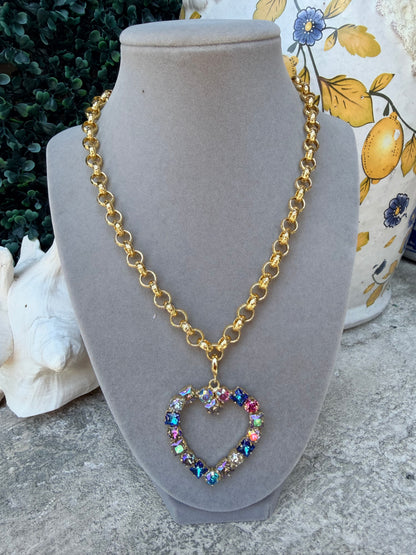 heart shaped pendant with round and square crystals in blue tones on a gold necklace 