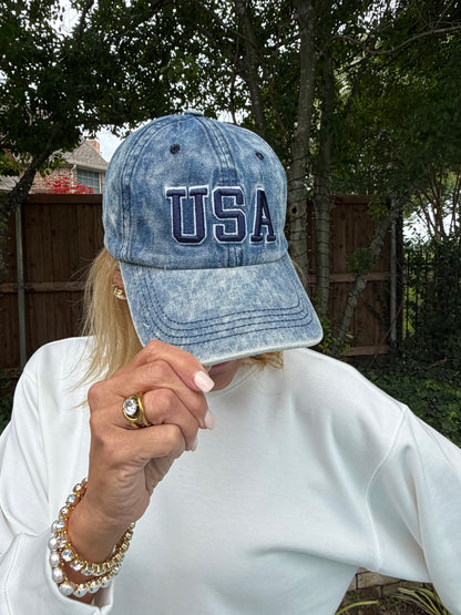 Person wearing a blue denim cap with 'USA' embroidery.