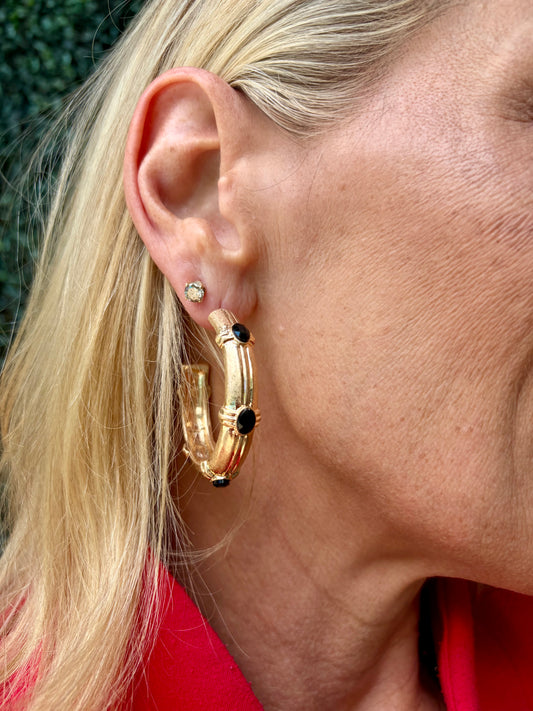 gold hoop earring with black crystals on it