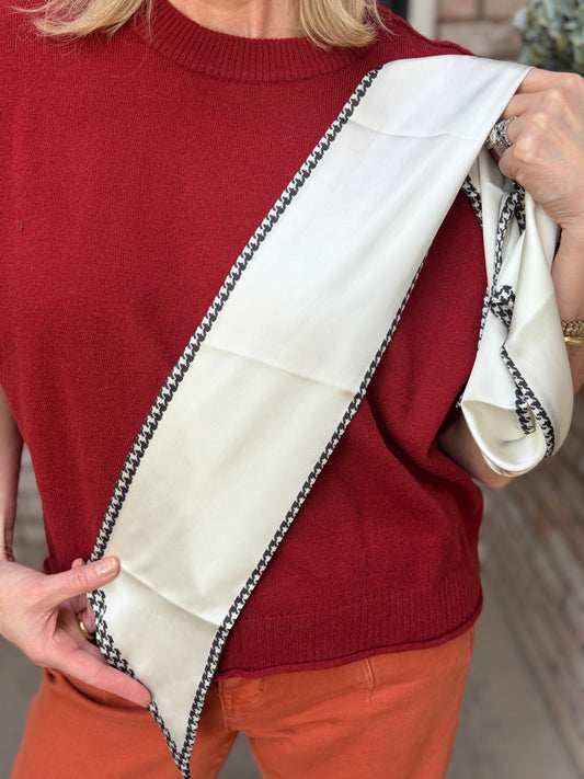 cream-colored scarf with black and white houndstooth patterned border
