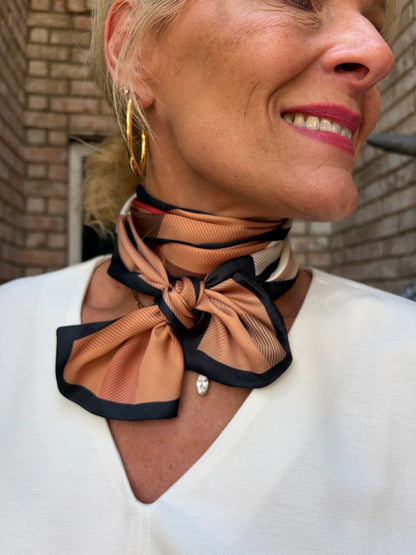 woman wearing a camel, black, cream and red check scarf around her neck