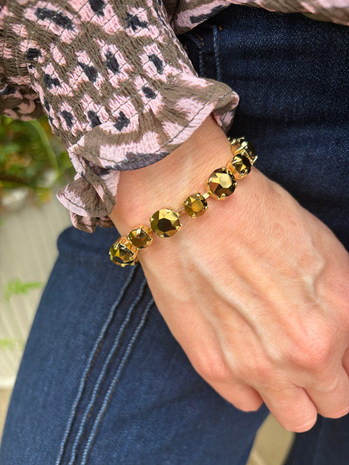 a gold foil beaded bracelet with faceted round stones that alternate size with magnetic closure.
 