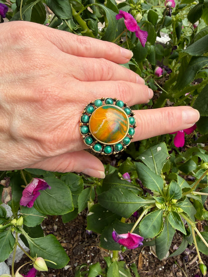 round ring with green stones and yellow and green stone in the middle. Set in a 22kt gold plated adjustable band