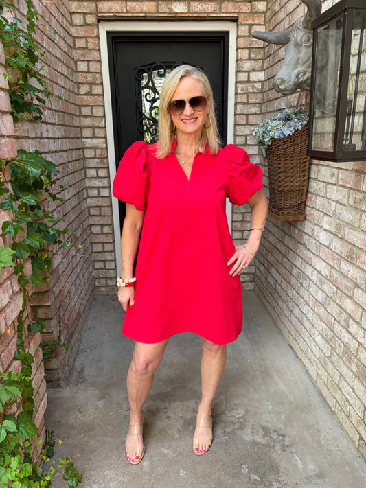 woman in red vneck dress with puff sleeve and faux ruffle collar that is knee length aline