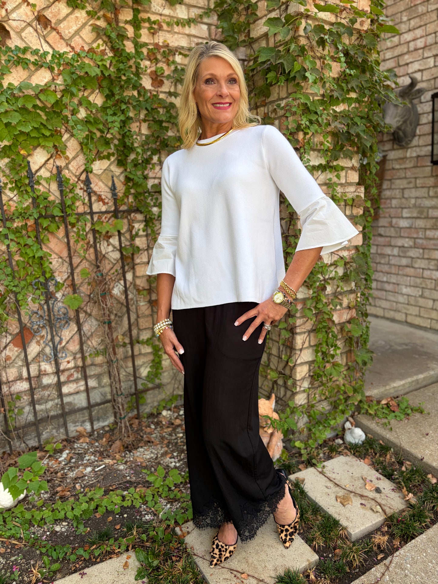 a sikly black pant with lace detail at hem paired with a white light weight sweater top with poplin detail on cuff