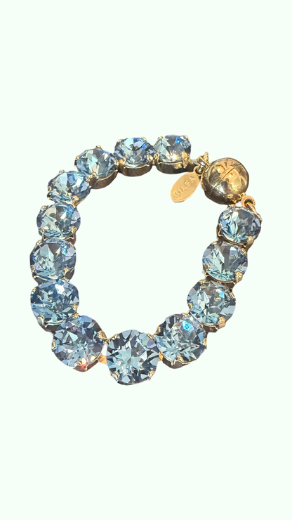 A magnetic gold water resistant bracelet with crystal round baby blue stones