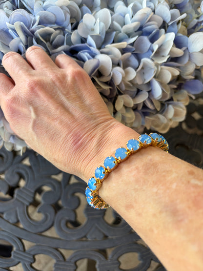 Hand wearing a denim blue and gold gemstone stretch bracelet - water resistant 