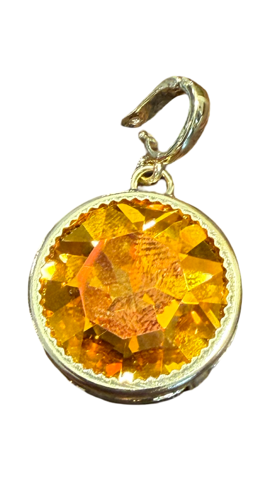 a gold round crystal necklace or bracelet charm that is water resistant topaz color