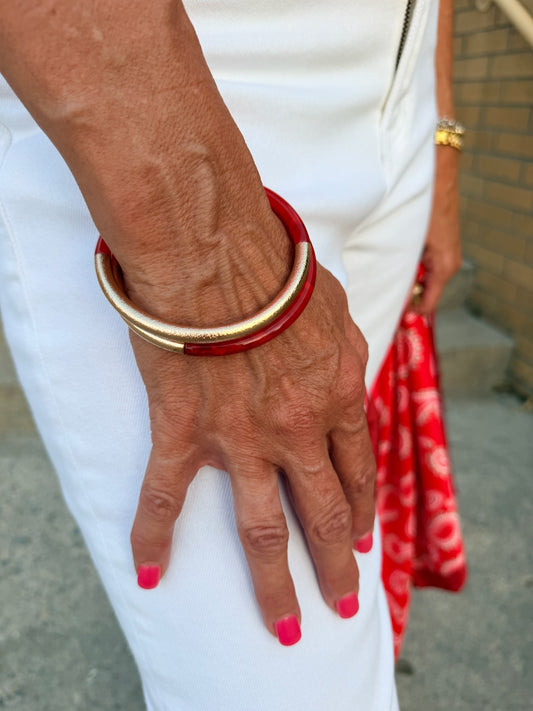 two bracelets with metallic gold and red on them