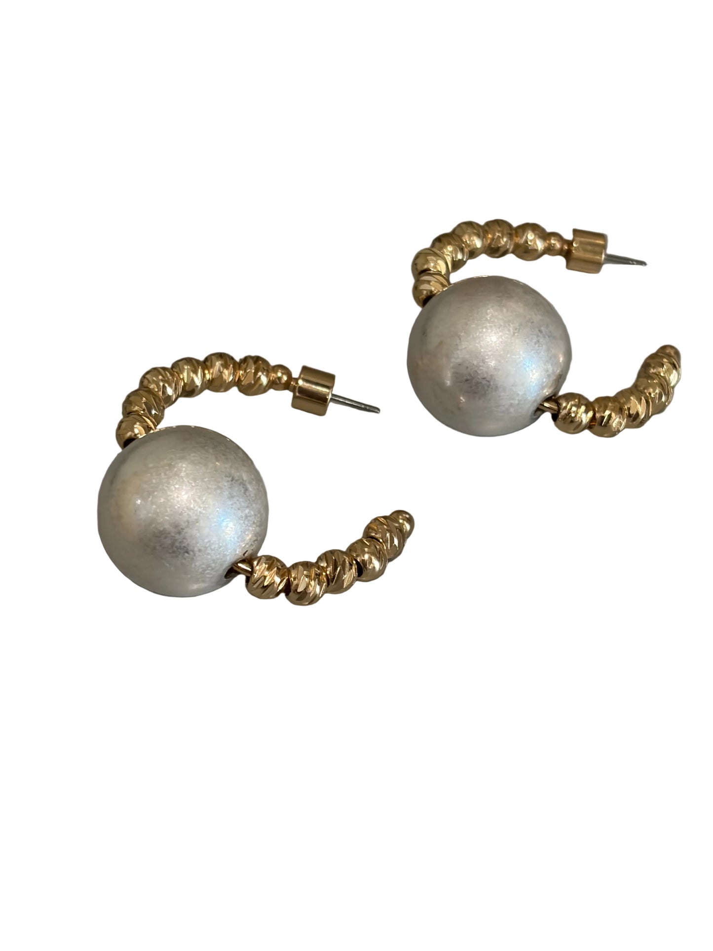A pair of gold hoop earrings with large, textured pearl round beads and smaller gold spacer beads, displayed on a gray surface.
