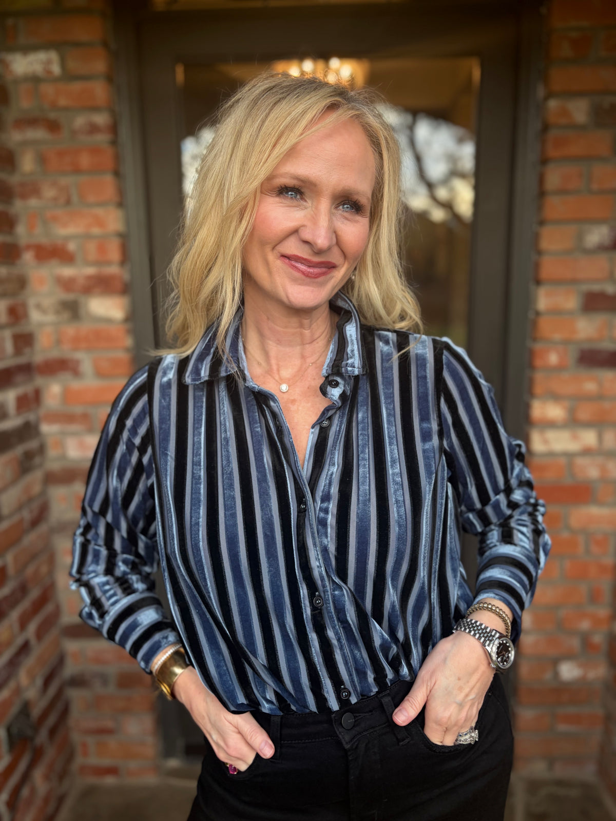 a blue and black striped button down blouse that is long sleeved in rich velvet