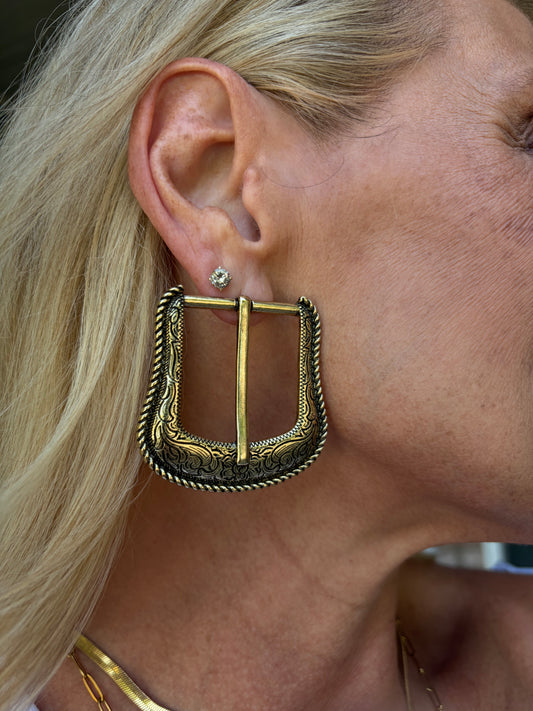 an antique, brass gold tone post earring of a unique belt buckle design