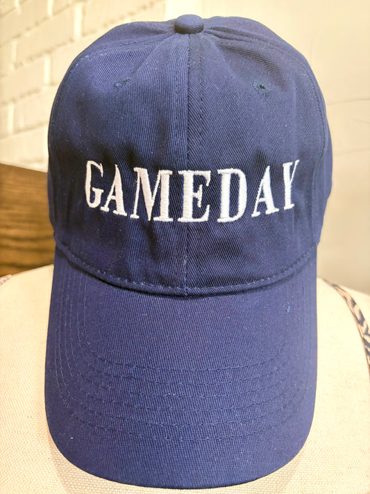 A navy blue baseball cap with 'GAMEDAY' embroidered in white block letters across the front