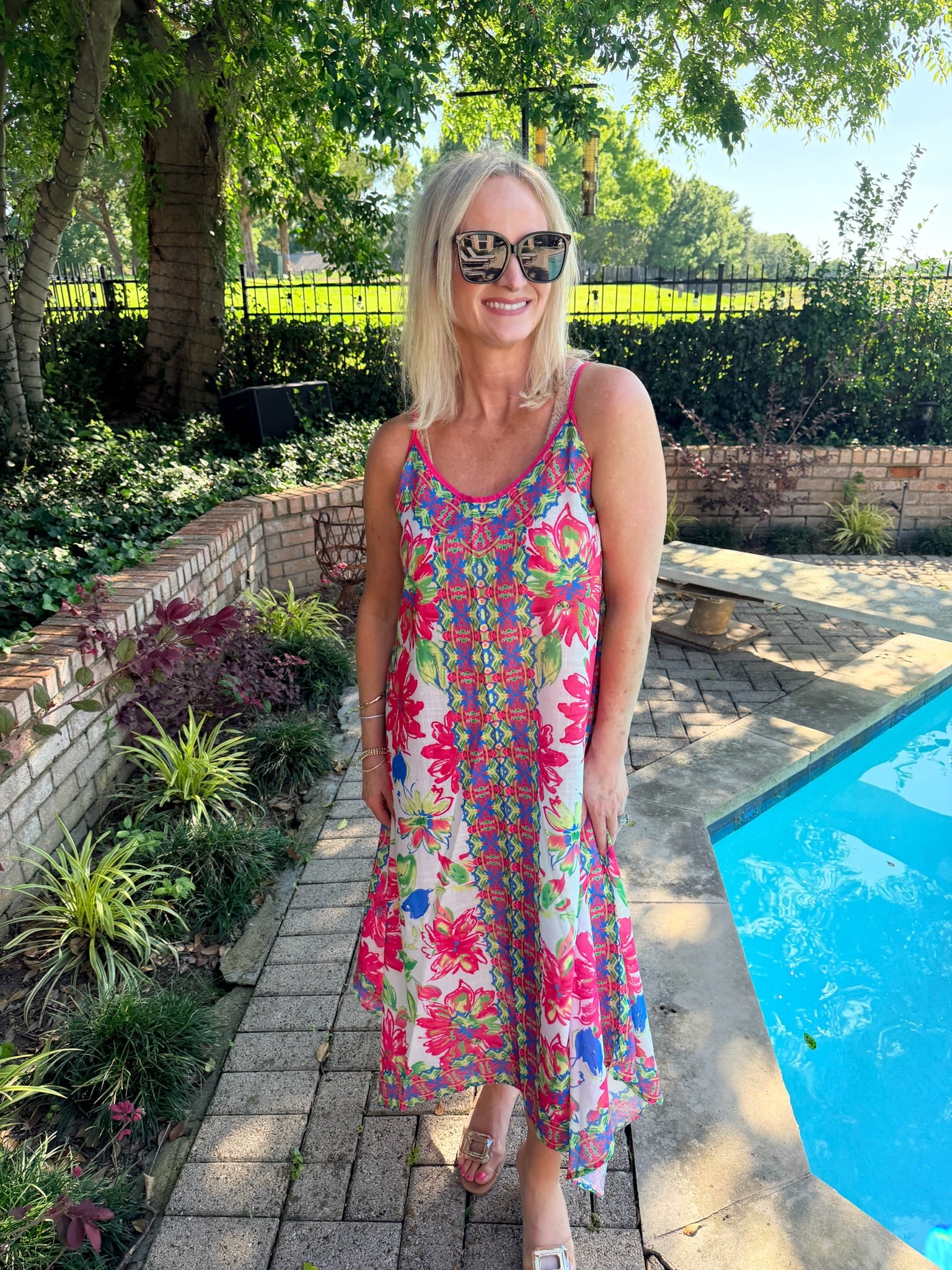 woman in colorful floral sundress/swimsuit cover up by pool