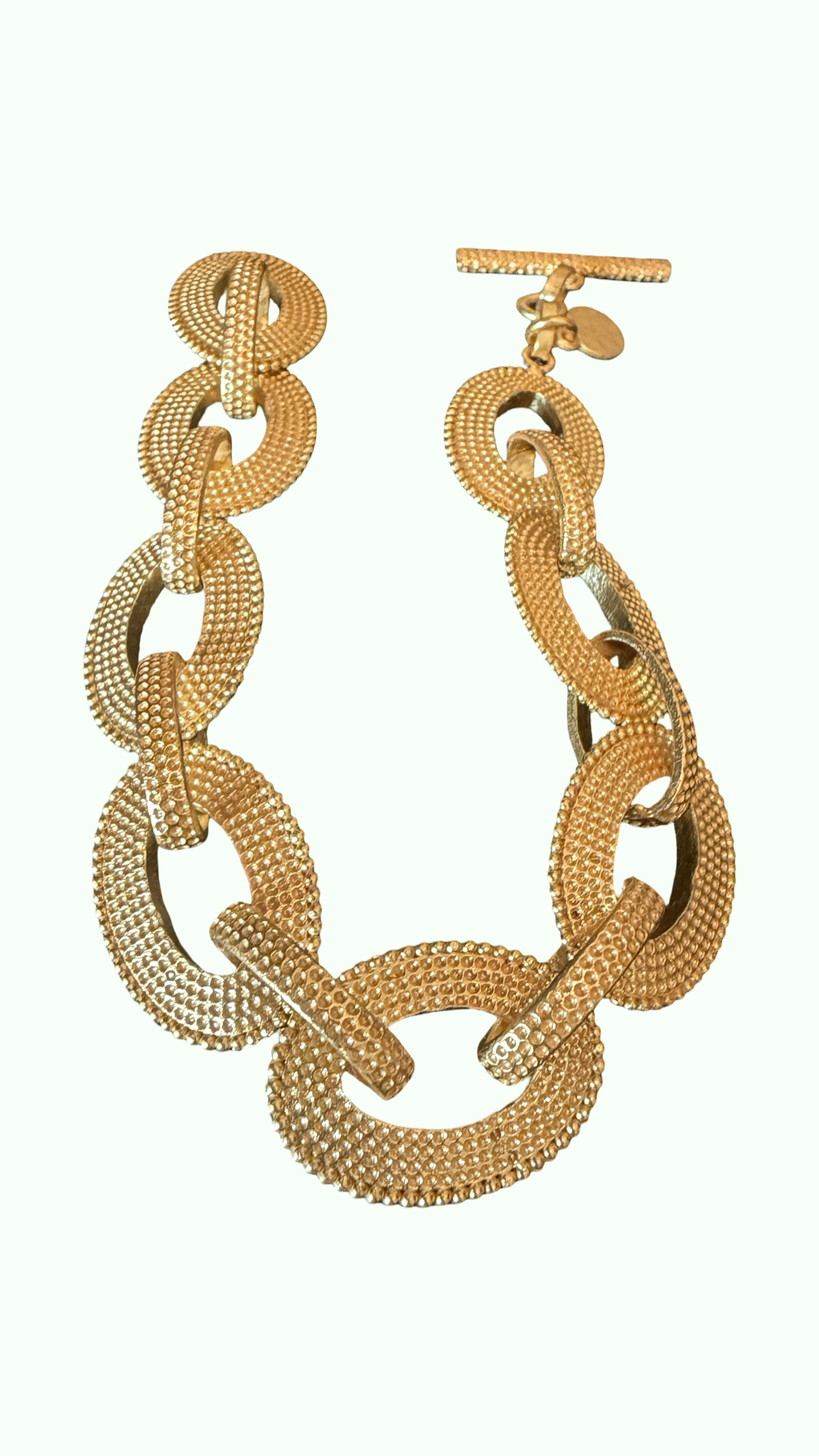 A flat link gold tone bracelet in bead texture 