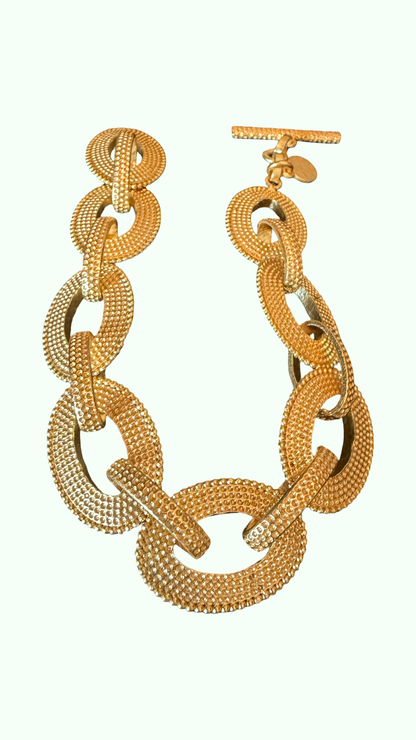 A flat link gold tone bracelet in bead texture 