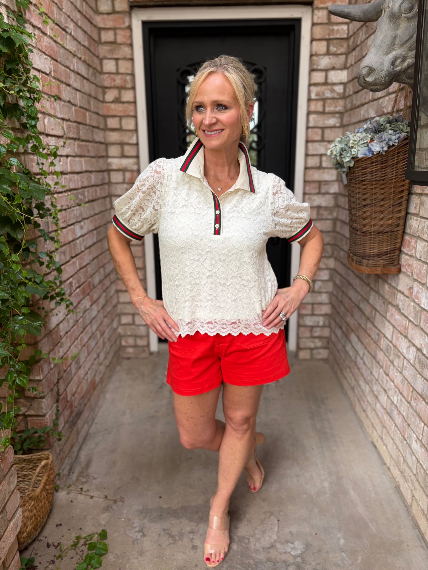 lace top with red and green stripe design and detail on the collar, front button down with red and green stripe detail on sleeve paired with red shorts