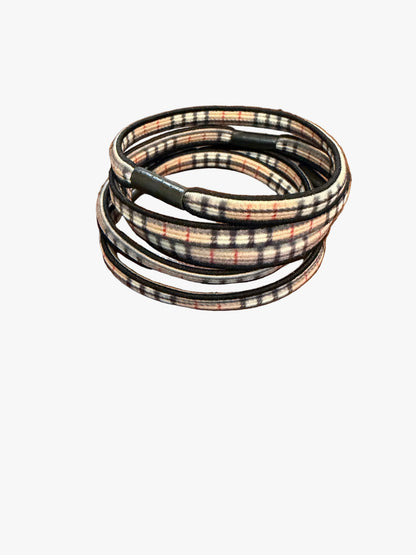 Plaid hairbands stacked on a wooden surface