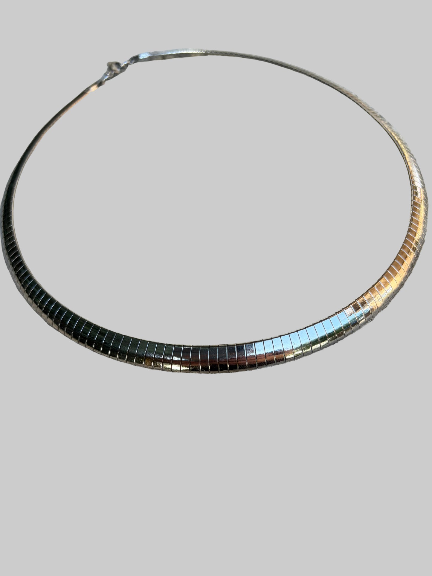 A water resistant silver snake chocker necklace. 