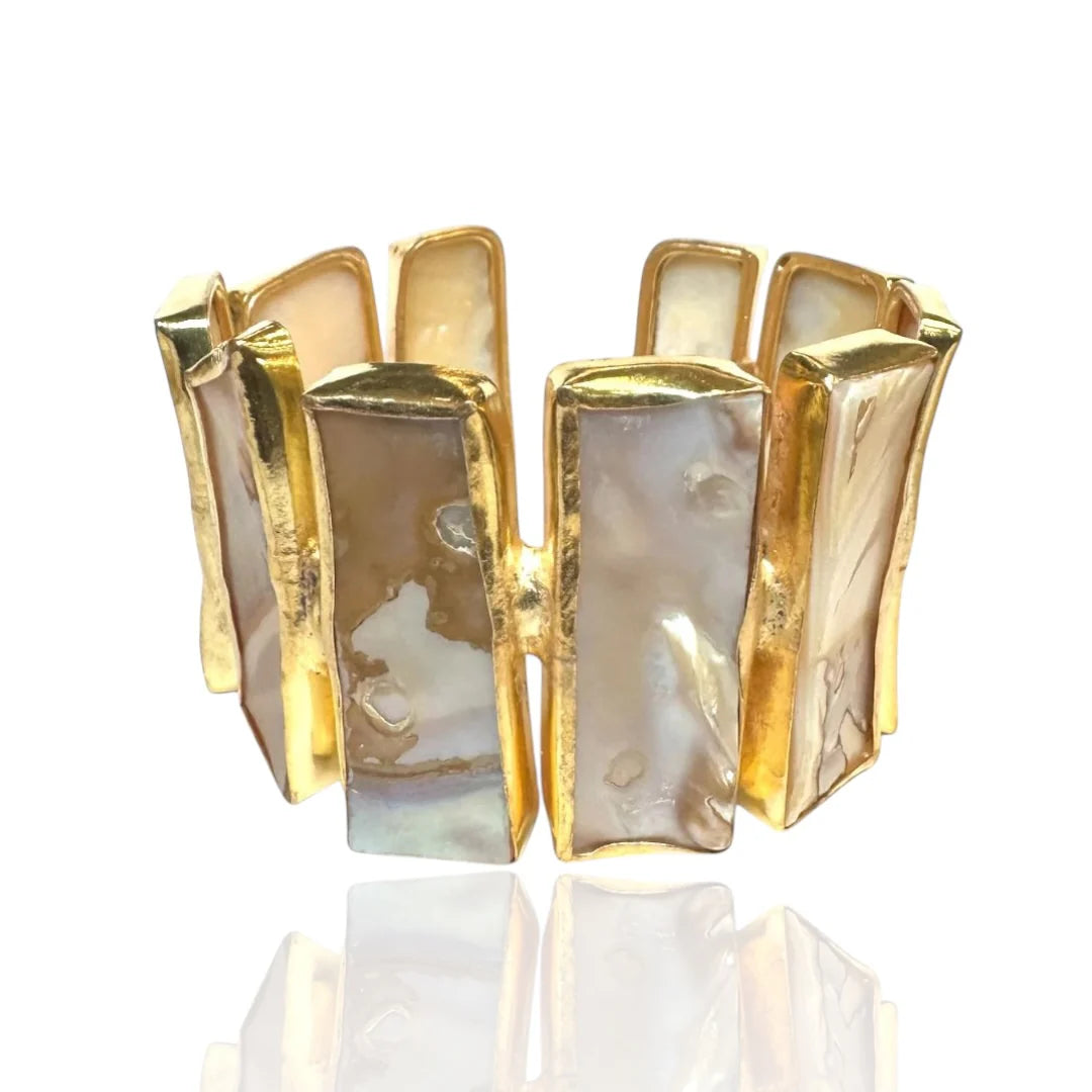 A gold-plated cuff bracelet featuring multiple vertical rectangular panels with iridescent mother-of-pearl inlays, displayed on a clean white background with a soft reflection below.