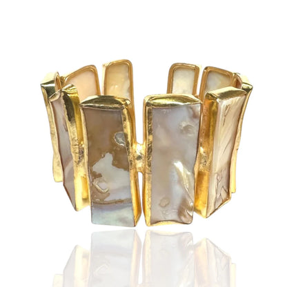 A gold-plated cuff bracelet featuring multiple vertical rectangular panels with iridescent mother-of-pearl inlays, displayed on a clean white background with a soft reflection below.