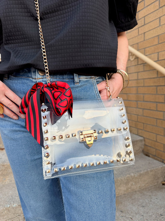 clear game day shoulder bag with gold-tone studs, a gold chain strap