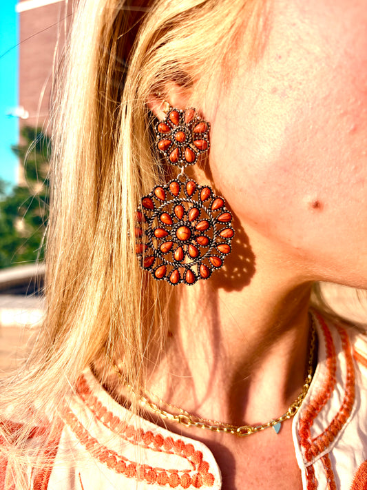  intricate bohemian-style drop earring. The earring features multiple circular floral clusters of orange beads set in dark metal