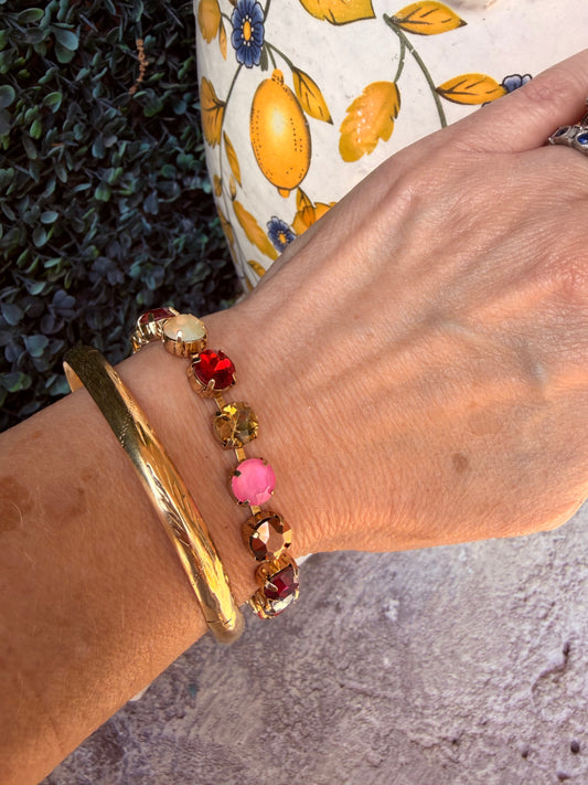 gold bracelet that is multicolor gemstones on a wrist

