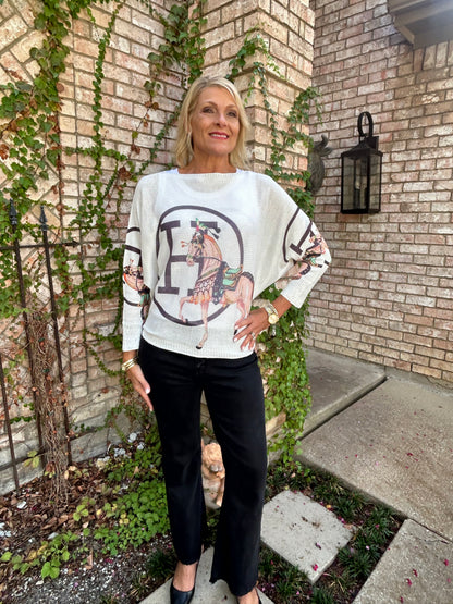 a white light weight italian knit with a black H design and a horse. 