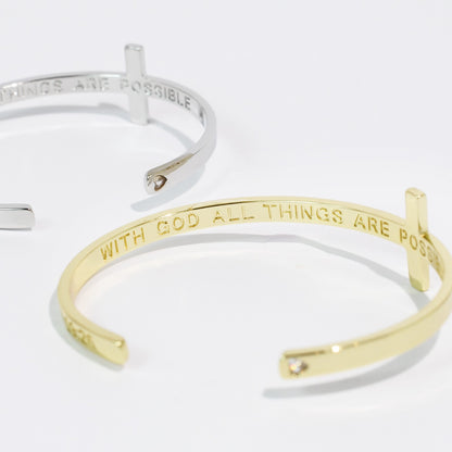 Gold and silver bangle bracelets with motivational phrases on a white background