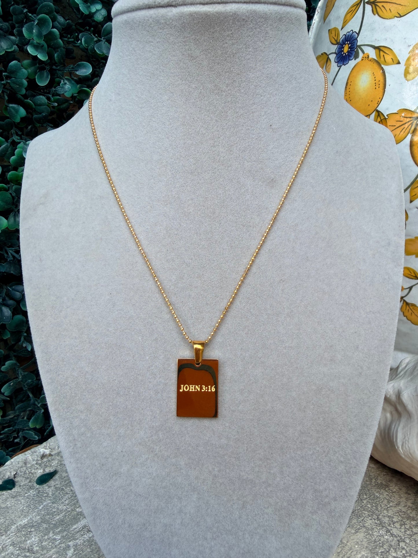 A gold chain necklace with a rectangular gold pendant engraved with 'JOHN 3:16', Stainless steel