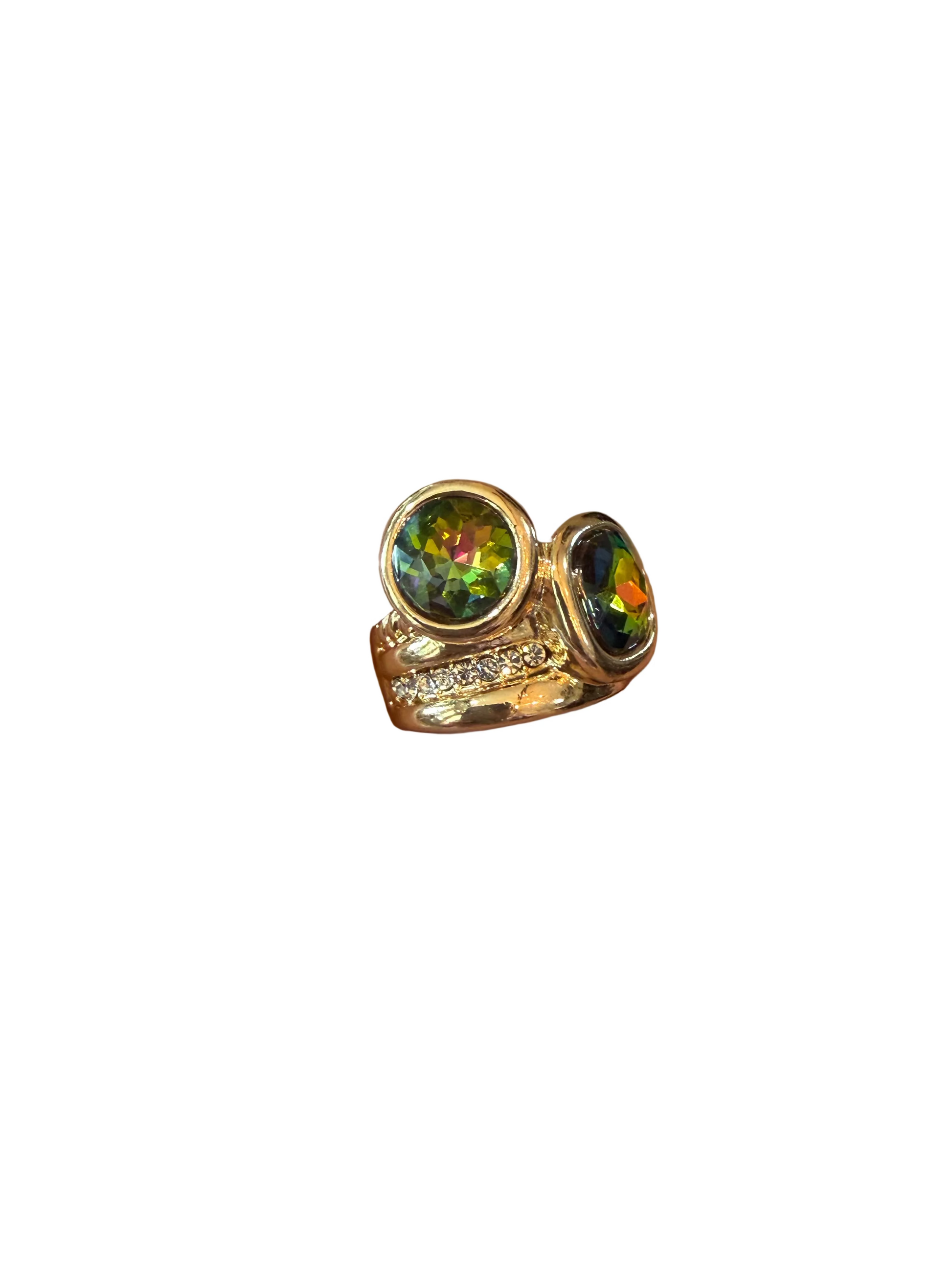 Gold ring with a colorful gemstone on a hand against a tiled floor background
