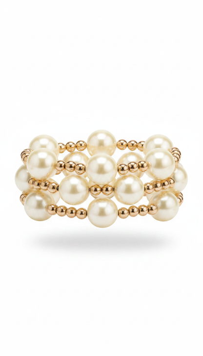 A stack of three pearl and gold beaded stretch bracelets  on a clean white background.