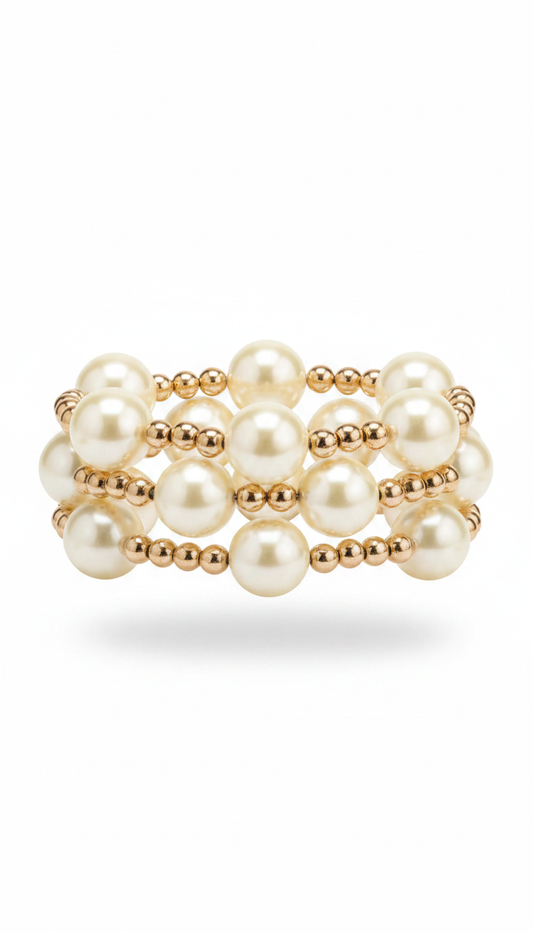 A stack of three pearl and gold beaded stretch bracelets  on a clean white background.