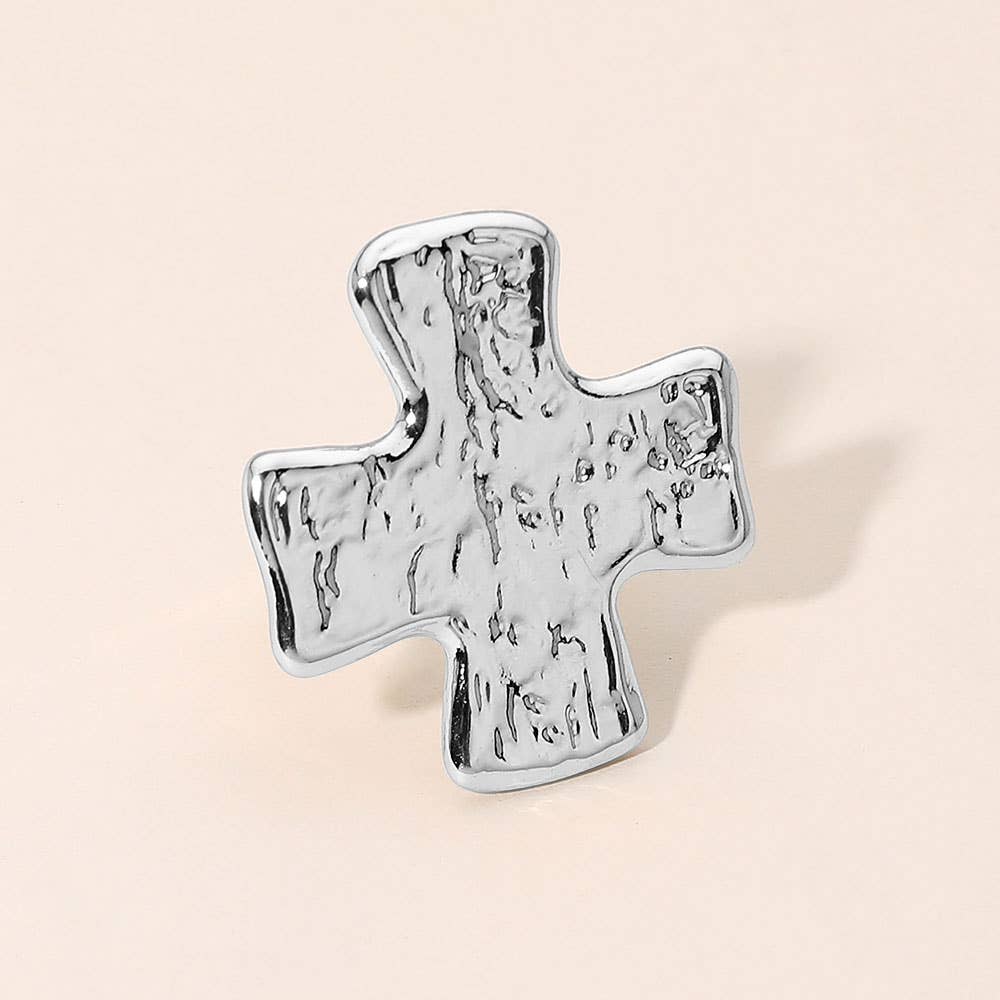 A silver cross-shaped ring with a textured, hammered finish 