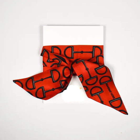 A red silk scarf with a black horsebit pattern