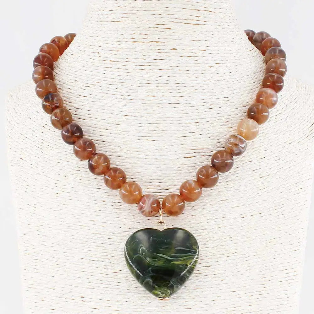 A resin transulescent, brown beaded necklace with a green heart pendant