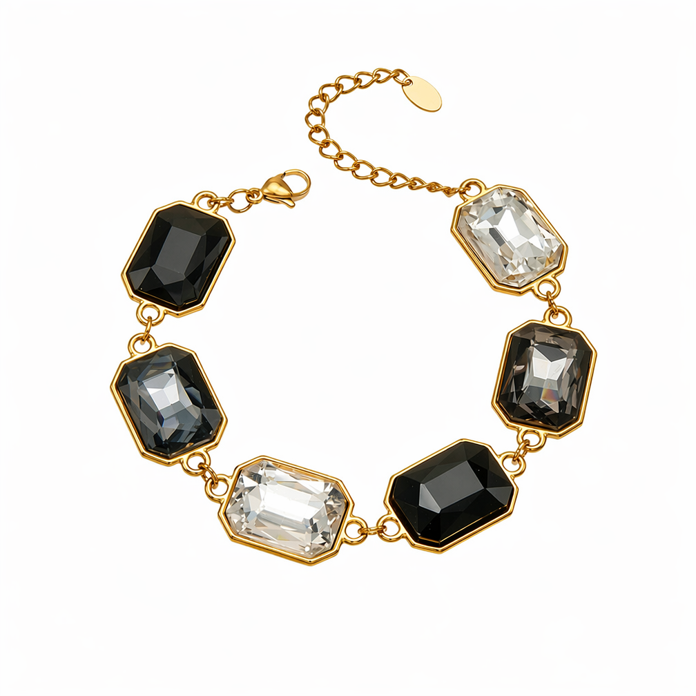 A gold-tone link bracelet featuring six rectangular faceted gemstones in alternating black, smoky gray, and clear crystal settings, displayed on a clean white background.