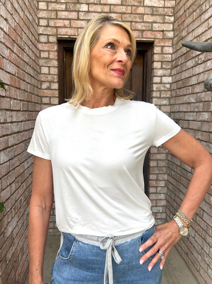 woman wearing a short sleeve, looser fit elevated white tee with denim. 