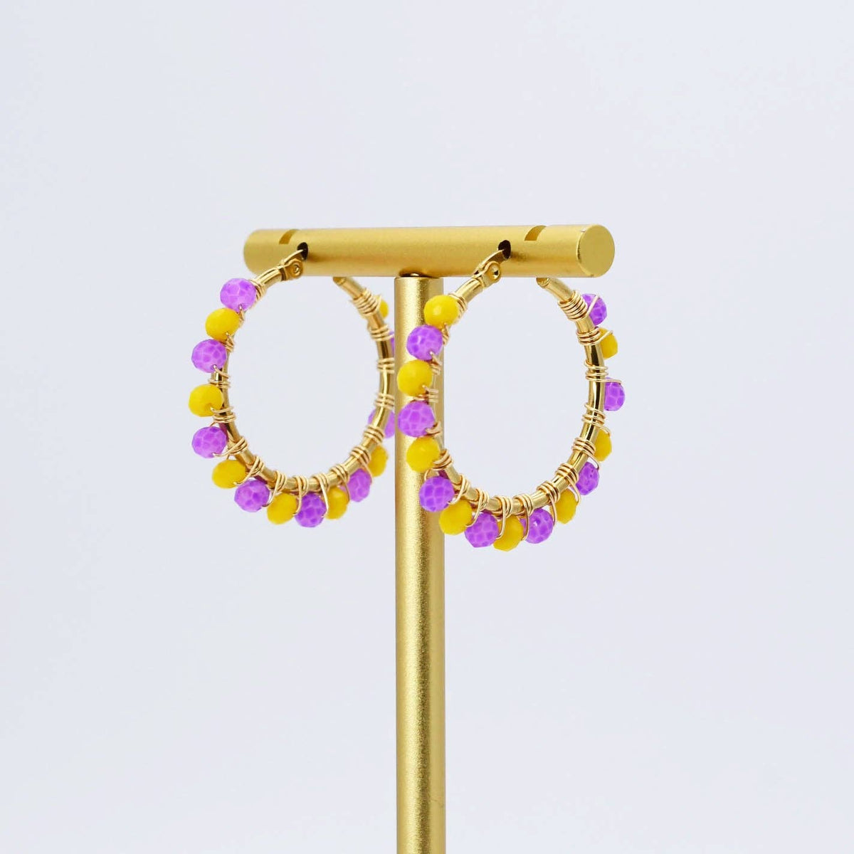 Gold hoop earrings with small yellow and purple faceted beads