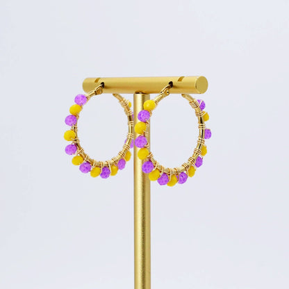 Gold hoop earrings with small yellow and purple faceted beads