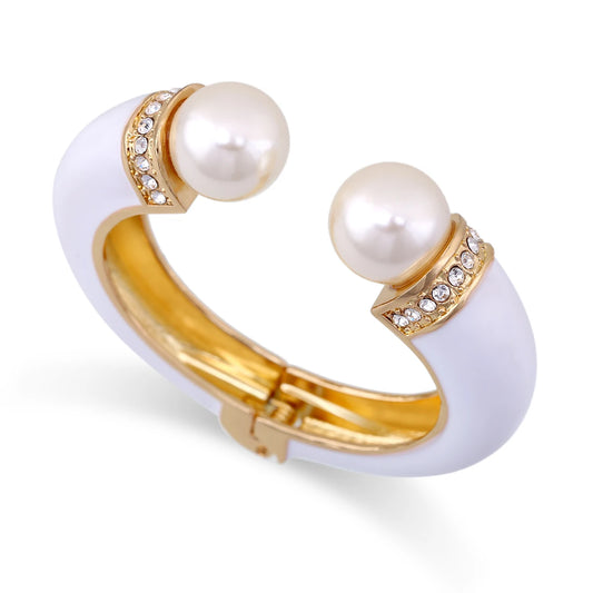 White cuff bracelet with gold accents and pearl-like beads on a white background