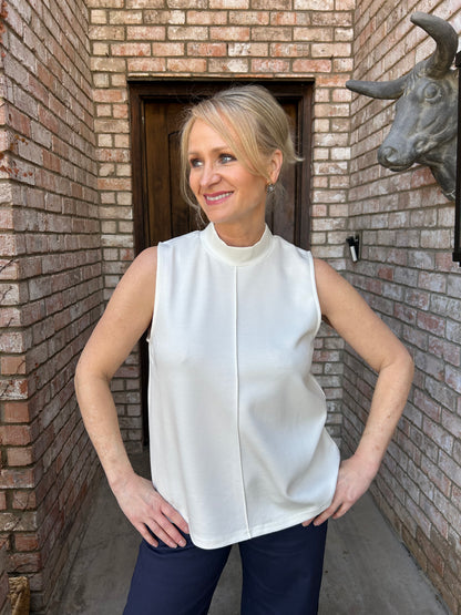 woman in off white, modal sleeveless top with crew neck and navy pants